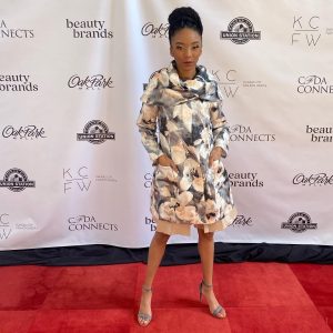 Eugena posing on a red carpet at the fashion show