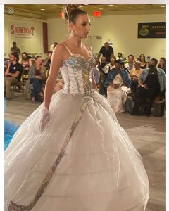 Casey walking in a gown on the runway 
