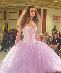 Madison walking in a gown on the runway