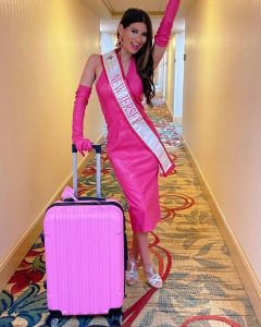 Gianna posing in her Miss Teen Universe New Jersey sash, gown, and a suitcase