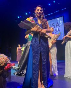 Nicole posing at the pageant in her gown after winning