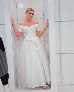 Lizzy posing on set in a bridal gown for the Earth Day Fashion Show