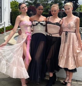 Katie, Tasha, Rylee, & Stephanie posing backstage in different fashion outfits at the fahsion show