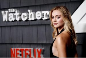 Isabel in front of a promotional sign for the show and Netflix