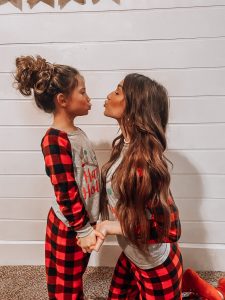 Kaesyn in a matching outfit facing a small girl making a kissy face with her