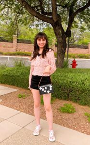 body shot of Tiffany outside wearing a fashionable outfit and purse